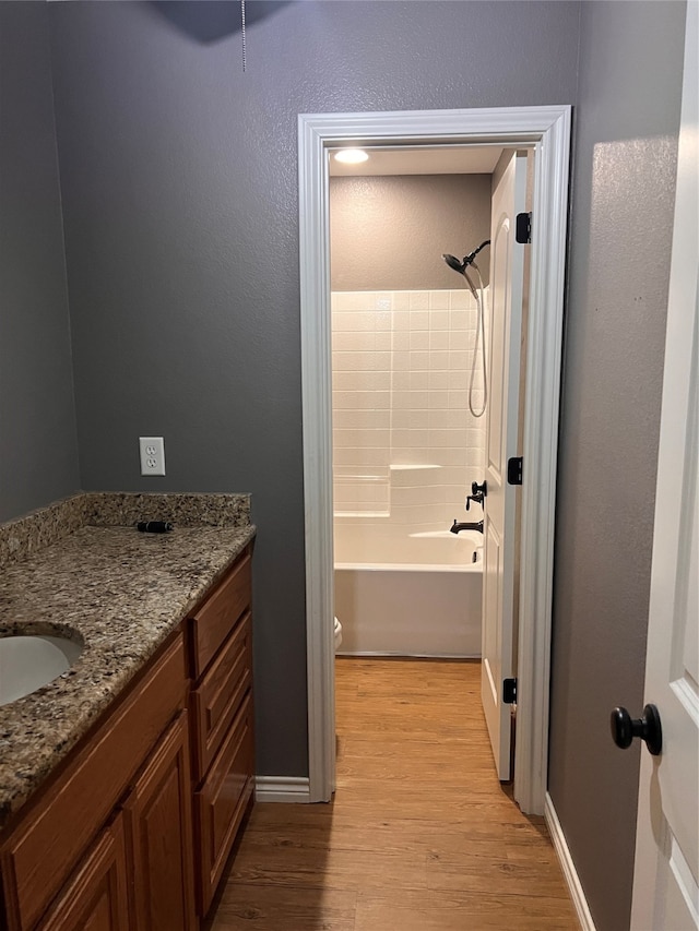 full bathroom featuring bathtub / shower combination, vanity, wood-type flooring, and toilet