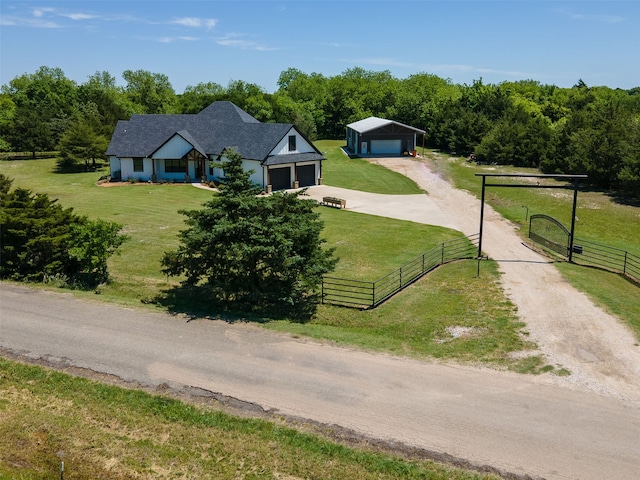 view of front facade featuring a rural view, a front yard, and a garage