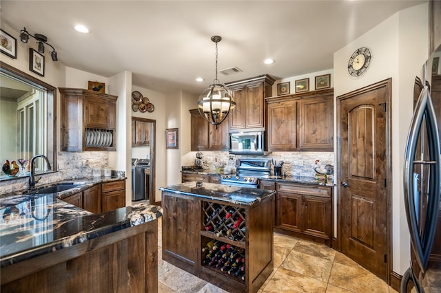 kitchen with decorative light fixtures, sink, dark stone countertops, decorative backsplash, and stainless steel appliances