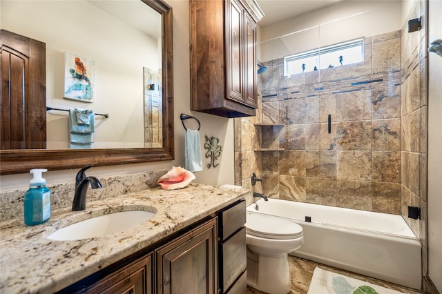 full bathroom with tiled shower / bath, vanity, and toilet