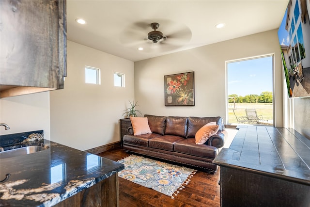 living room featuring dark wood-type flooring, ceiling fan, plenty of natural light, and sink