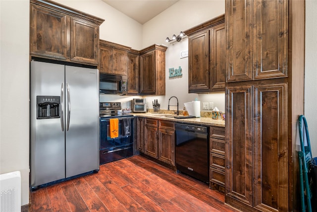 kitchen featuring sink, dark hardwood / wood-style flooring, black appliances, light stone countertops, and dark brown cabinets