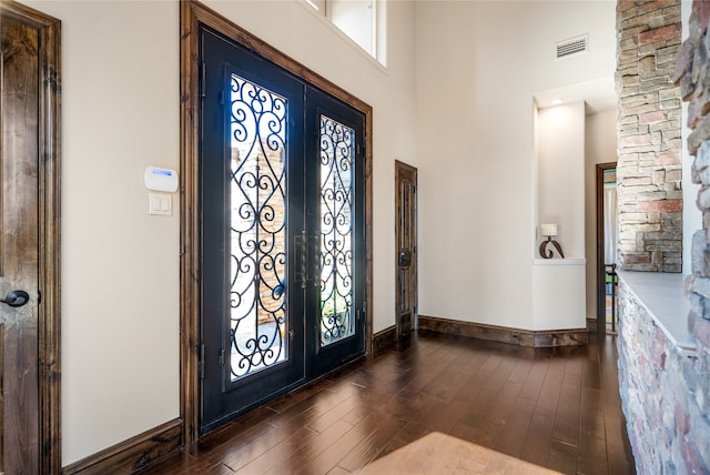 entryway featuring french doors, dark wood-type flooring, and a high ceiling