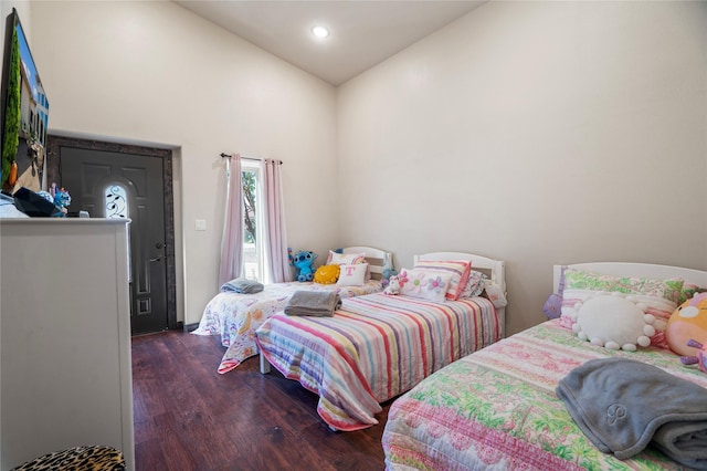 bedroom featuring dark wood-type flooring and high vaulted ceiling