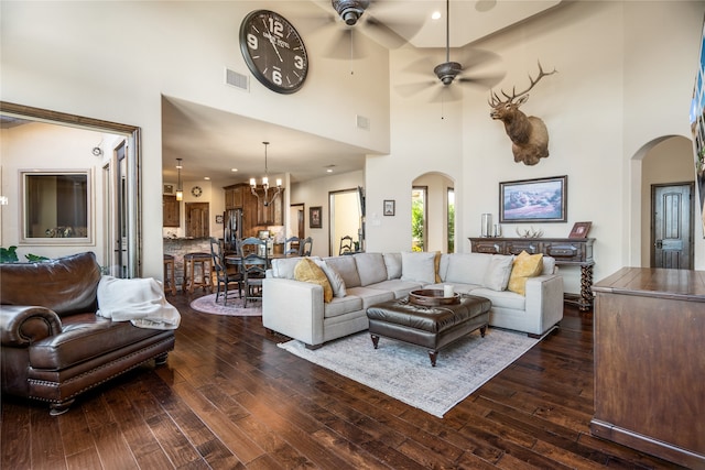 living room with dark wood-type flooring and ceiling fan with notable chandelier