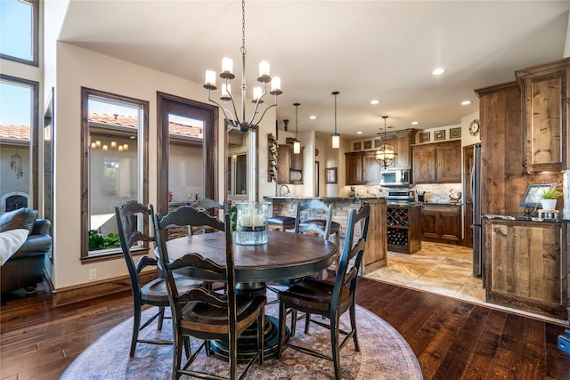 dining room with plenty of natural light, a notable chandelier, and light wood-type flooring