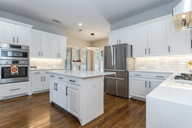 kitchen with dark hardwood / wood-style floors, hanging light fixtures, a center island, white cabinets, and appliances with stainless steel finishes