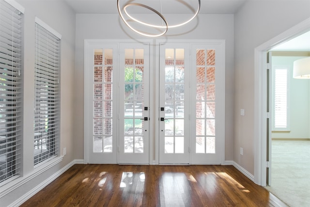 entryway with french doors, an inviting chandelier, and dark hardwood / wood-style flooring