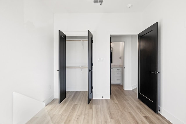 bedroom featuring light hardwood / wood-style floors and a closet