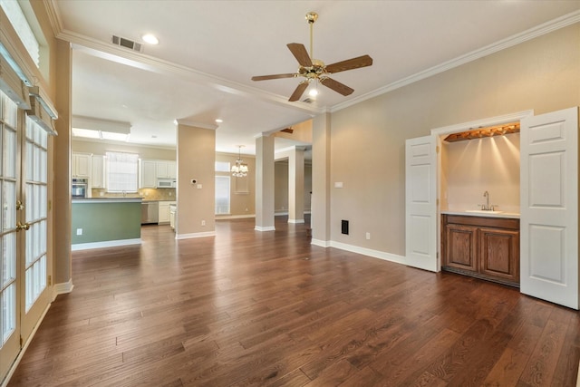 unfurnished living room with crown molding, ceiling fan with notable chandelier, dark hardwood / wood-style floors, and sink