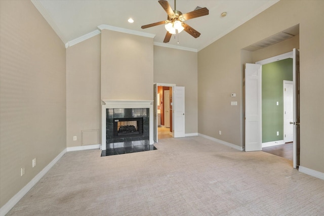 unfurnished living room featuring ceiling fan, light colored carpet, crown molding, and a tiled fireplace