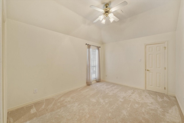 carpeted spare room with ceiling fan and vaulted ceiling