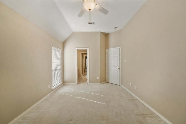 unfurnished bedroom featuring ceiling fan, light colored carpet, and lofted ceiling