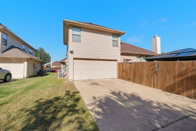 exterior space with central AC, a garage, and a lawn