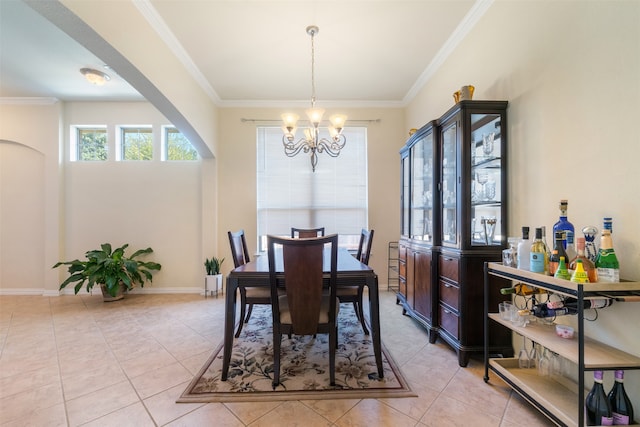 dining area with crown molding, light tile patterned floors, and an inviting chandelier