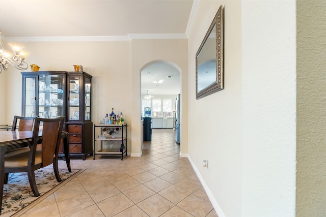 dining area with crown molding, ceiling fan with notable chandelier, and light tile patterned floors