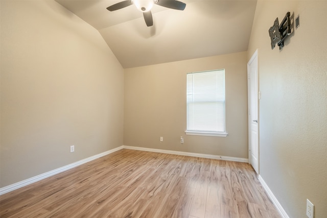 spare room featuring ceiling fan, vaulted ceiling, and light wood-type flooring