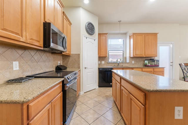 kitchen featuring hanging light fixtures, light tile patterned floors, stainless steel appliances, sink, and a center island