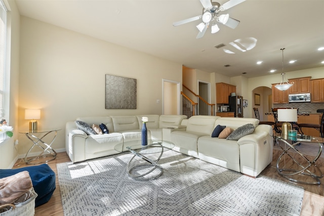 living room with light hardwood / wood-style flooring and ceiling fan