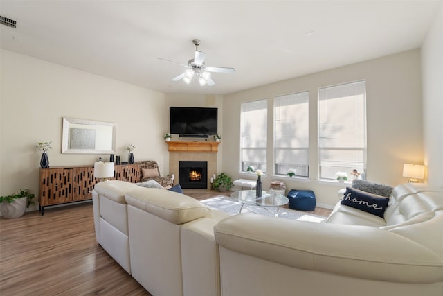 living room with hardwood / wood-style flooring, a fireplace, and ceiling fan