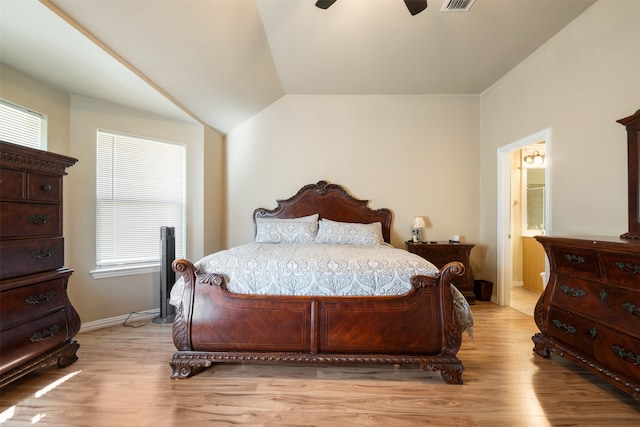 bedroom featuring lofted ceiling, ensuite bath, light wood-type flooring, and ceiling fan