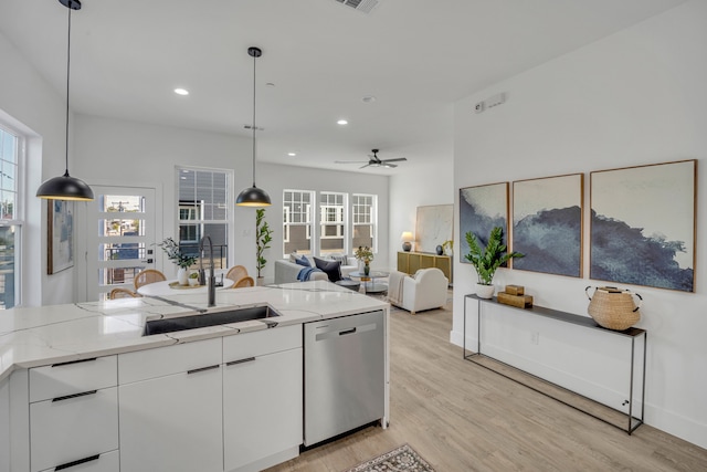 kitchen featuring stainless steel dishwasher, sink, white cabinets, and pendant lighting