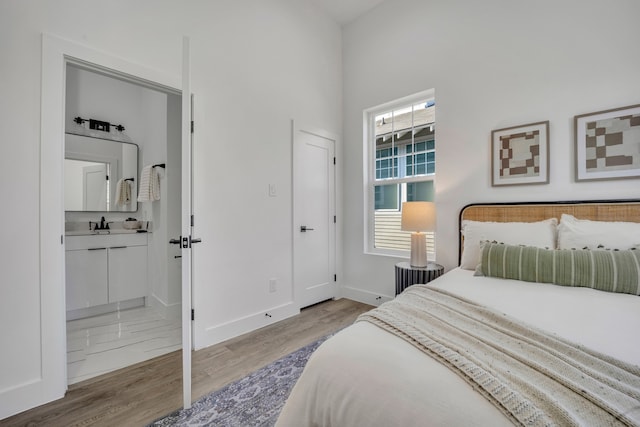 bedroom with light hardwood / wood-style floors and ensuite bath