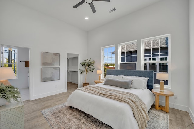 bedroom with a high ceiling, light hardwood / wood-style floors, and ceiling fan