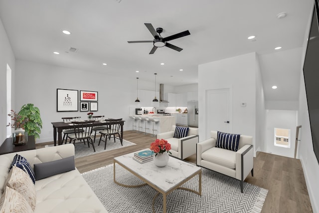 living room featuring light hardwood / wood-style flooring, heating unit, and ceiling fan