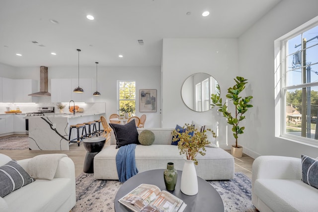 living room with sink and light wood-type flooring