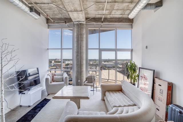 living room with radiator, concrete floors, and a towering ceiling