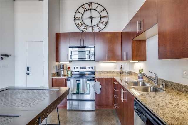 kitchen with light stone counters, appliances with stainless steel finishes, and sink