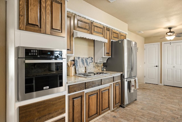 2720 N US-377, Stephenville, TX 76401 - kitchen featuring appliances with stainless steel finishes, decorative backsplash, brick floor, under cabinet range hood, and ceiling fan