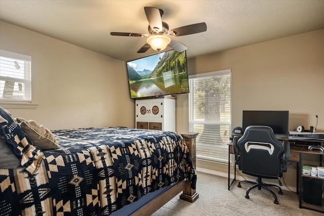 bedroom featuring ceiling fan, multiple windows, and light colored carpet