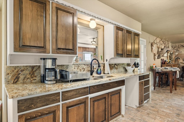 2720 N US-377, Stephenville, TX 76401 - kitchen featuring brick floor, a sink, and light stone counters