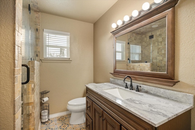 2720 N US-377, Stephenville, TX 76401 - full bath featuring vanity, toilet, a textured wall, baseboards, and a stall shower