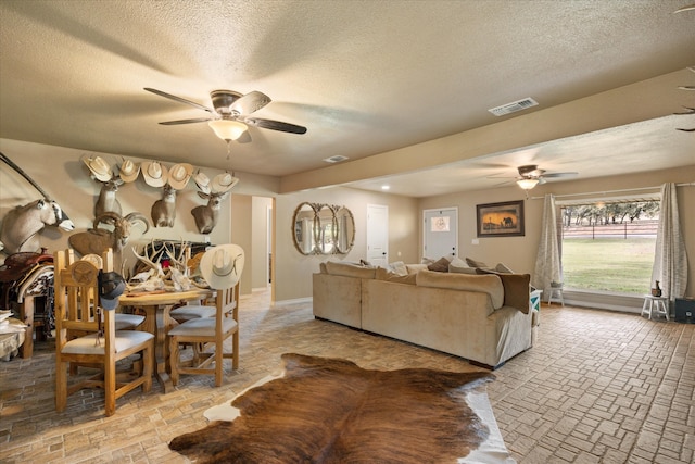 living room featuring a textured ceiling and ceiling fan