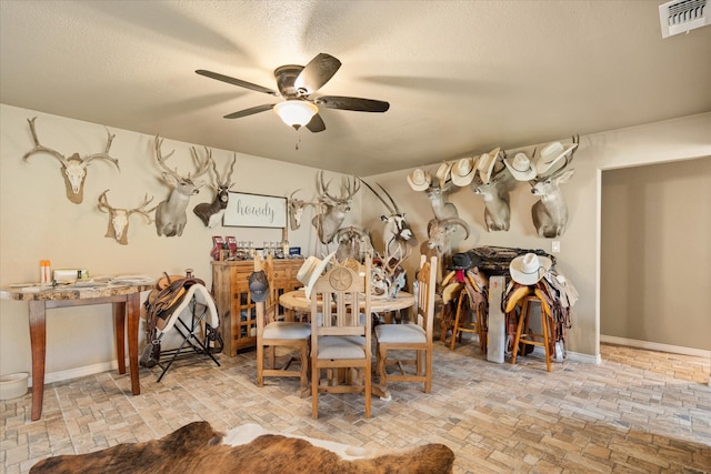 dining space featuring ceiling fan and a textured ceiling