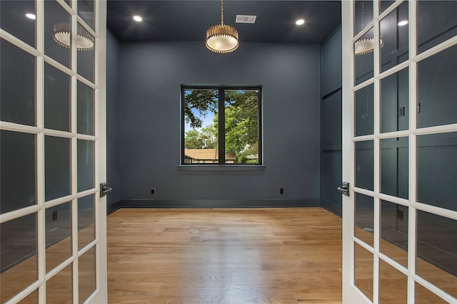 empty room with french doors and wood-type flooring