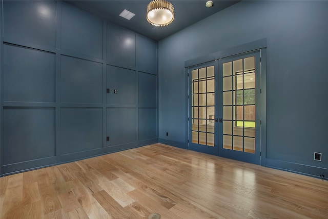 empty room featuring french doors and light hardwood / wood-style floors