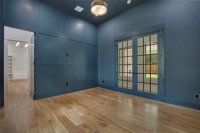 unfurnished room featuring french doors and light wood-type flooring