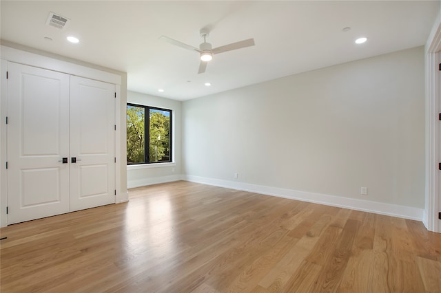 unfurnished bedroom with light hardwood / wood-style flooring, a closet, and ceiling fan