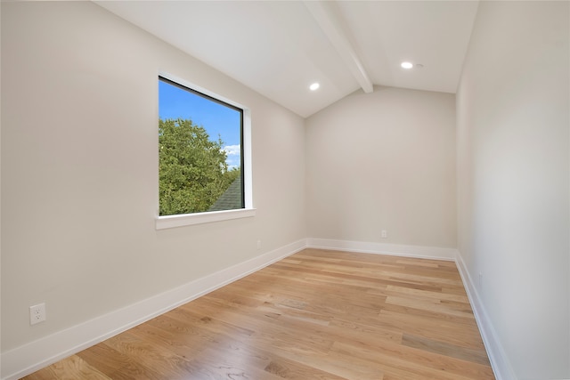 unfurnished room featuring vaulted ceiling with beams and light hardwood / wood-style floors