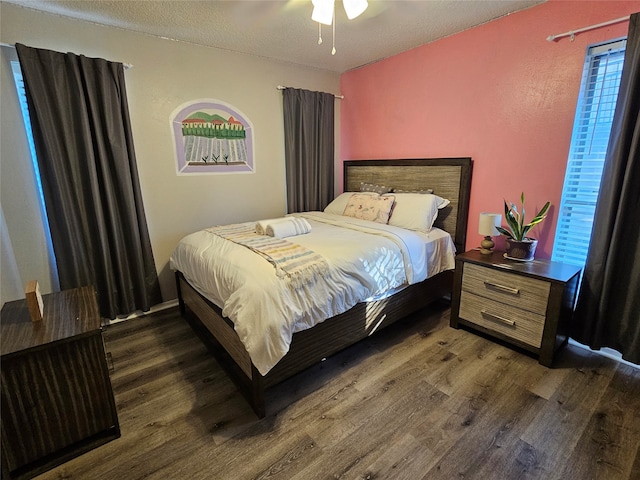 bedroom featuring a textured ceiling, ceiling fan, and dark hardwood / wood-style flooring