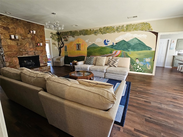 living room with dark wood-type flooring, crown molding, a notable chandelier, and a fireplace