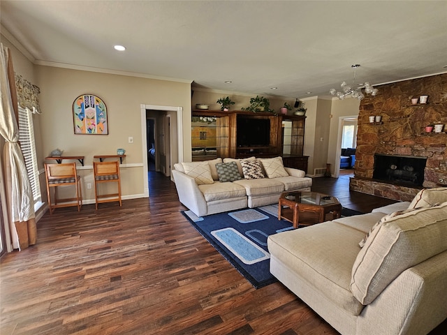 living room with crown molding, a chandelier, dark wood-type flooring, and a fireplace