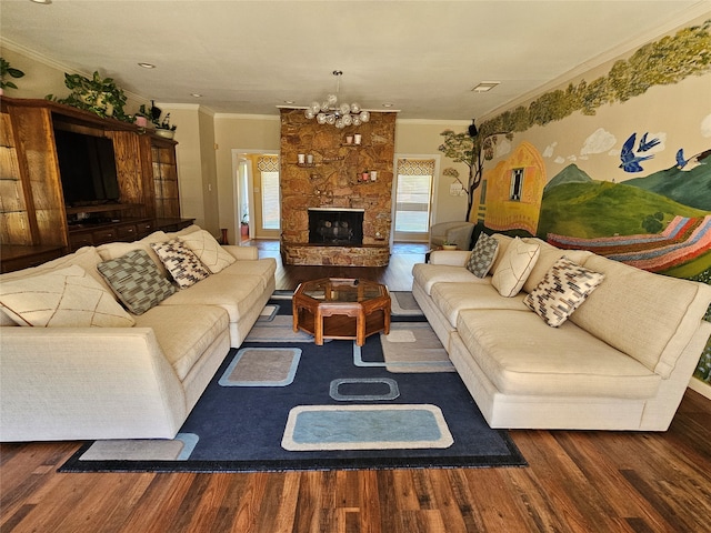 living room featuring a fireplace, ornamental molding, dark hardwood / wood-style flooring, and an inviting chandelier