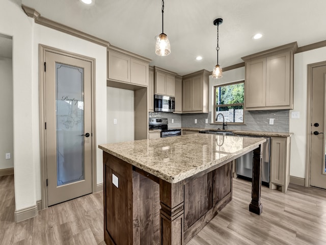 kitchen with light hardwood / wood-style flooring, stainless steel appliances, sink, crown molding, and a center island