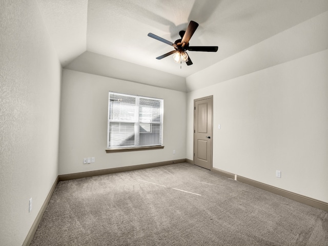 empty room featuring lofted ceiling, light colored carpet, and ceiling fan