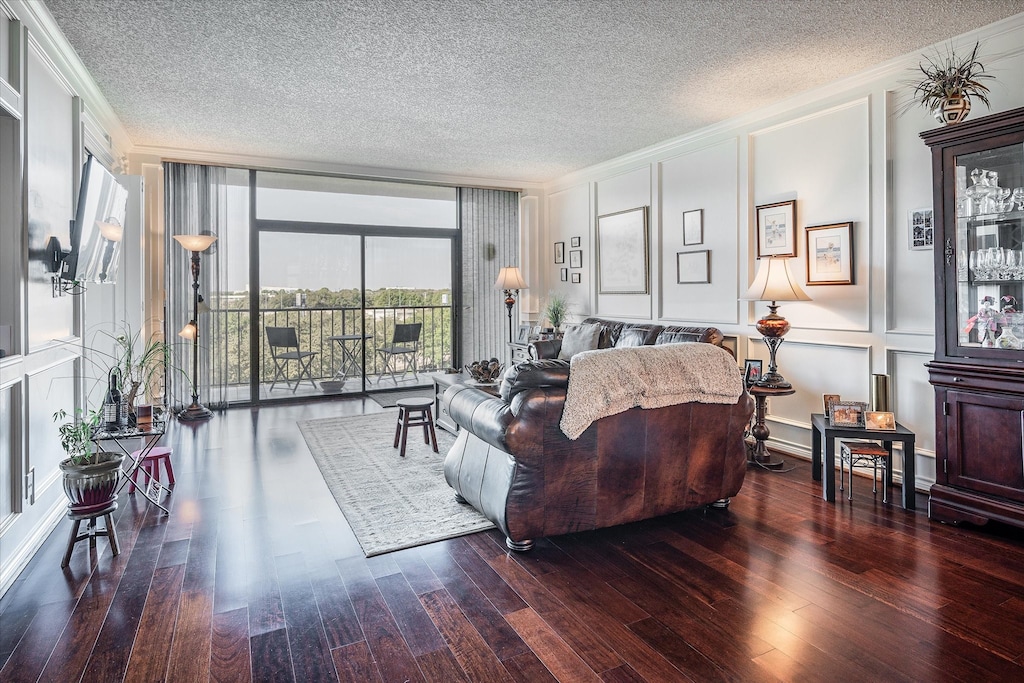 living room with a textured ceiling, crown molding, and dark hardwood / wood-style floors